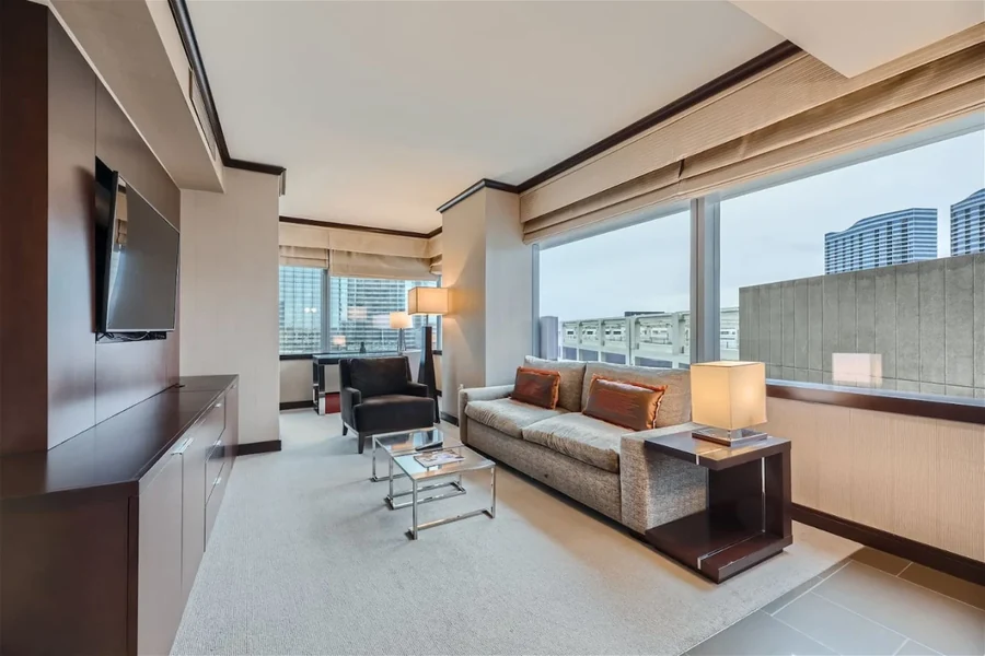 Living room with a sofa, armchair, television and city buildings