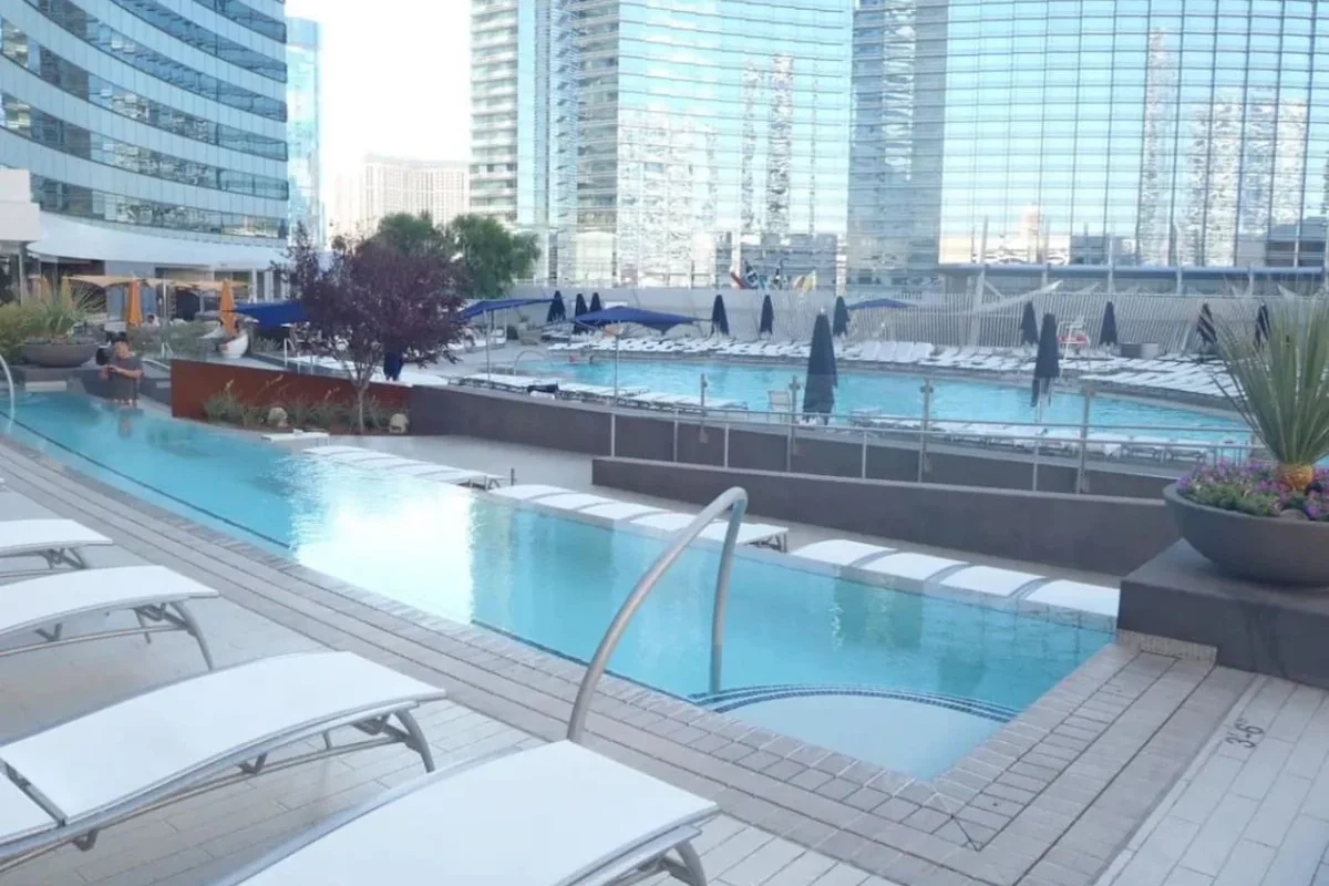 Las Vegas resort pool deck with loungers, palm trees and high-rise buildings